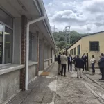 Asistentes a la visita, con el edificio rehabilitado a la izquierda y el castillete del pozo Candín al fondo.